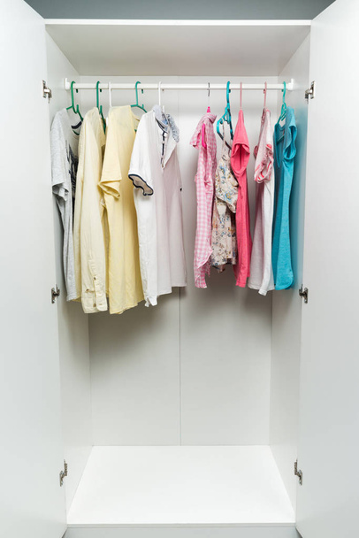 vêtements suspendus sur rail dans une armoire blanche
.  - Photo, image