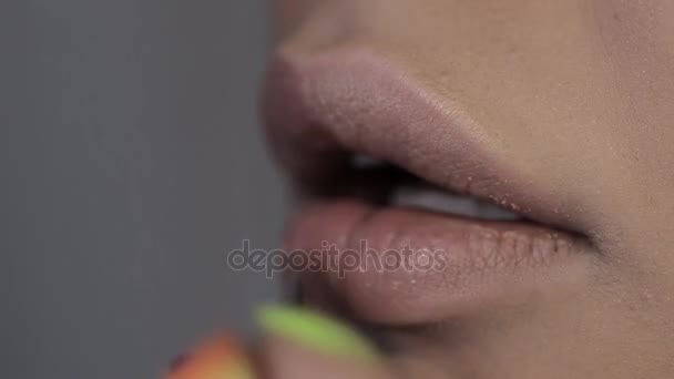 Make-up artist paints lips to beautiful girl, plump lips - Materiał filmowy, wideo