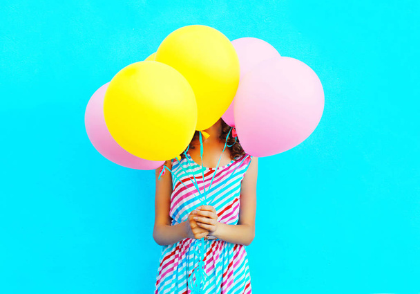 Woman is hides her head an air colorful balloons having fun over - Foto, Imagem