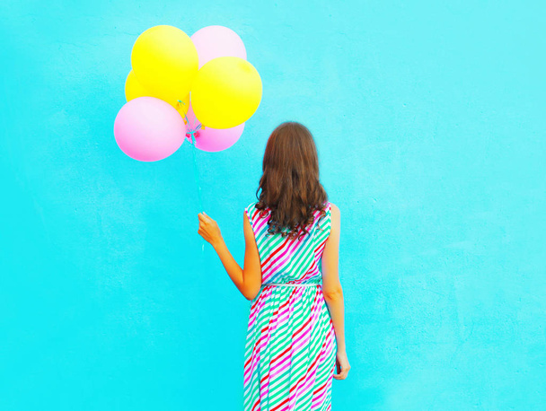 woman holds an air colorful balloons on a blue background - Fotoğraf, Görsel