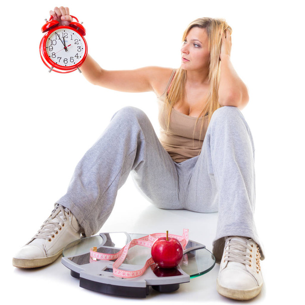 Woman holding apple, measuring tape and clock - Фото, изображение