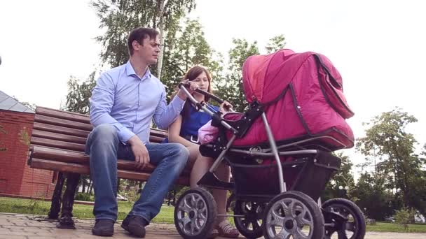 Piękna młoda matka, spacery z wózkiem dla dzieci w parku. - Materiał filmowy, wideo