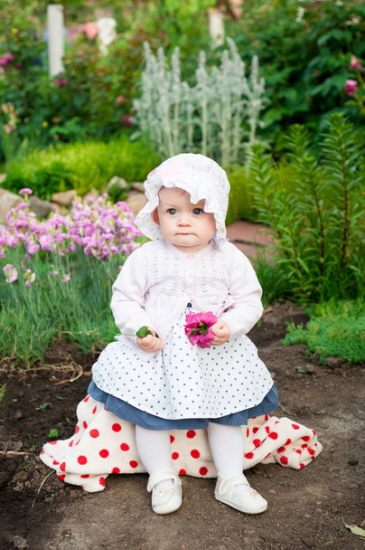 少女花と彼女の手でイチゴ、古いヨーロッパのウクライナは庭に散歩に少し赤ちゃん 8 ヶ月 - 写真・画像
