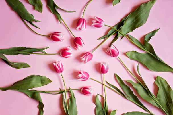 Arreglo floral creativo con tulipanes rosados y hojas verdes o
 - Foto, imagen