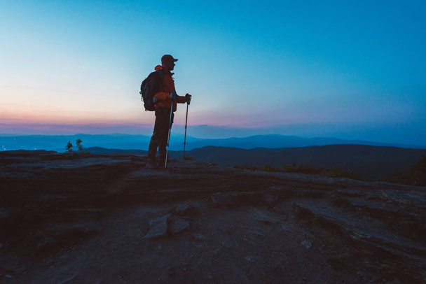 Человек турист с походами на вершине холма
 - Фото, изображение