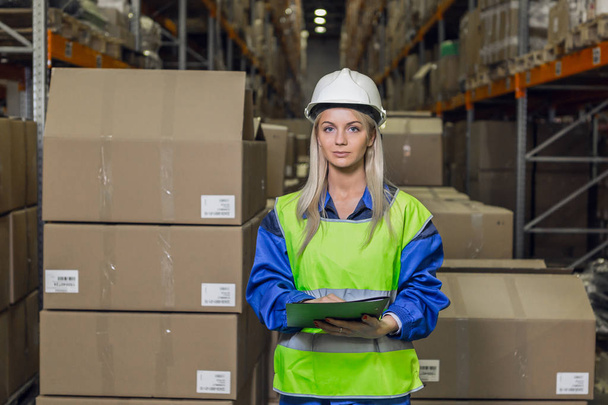 Female warehouse worker looking at camera - 写真・画像