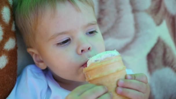 het kind eet een ijsje van wafel cup bij close-up - Video