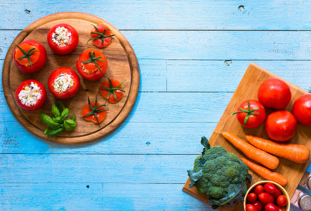 Stuffed tomatoes with cheese, and different vegetables, on a woo - Photo, image