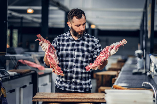 Bearded butcher holds meat - Photo, Image