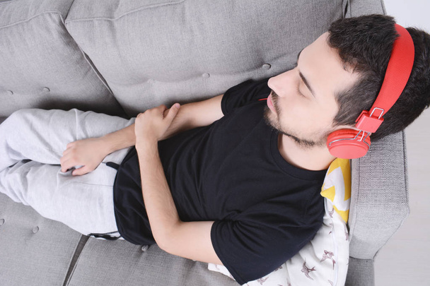 Man listening music on couch. - Zdjęcie, obraz