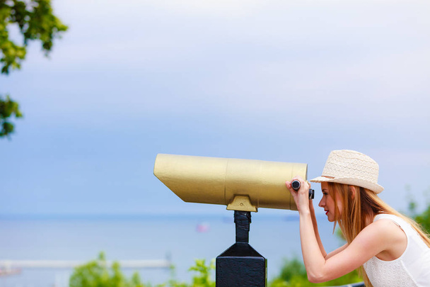 Woman tourist with sun hat looking through telescope - Photo, Image