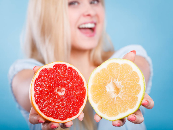 Woman holding red and green grapefruit - Foto, imagen