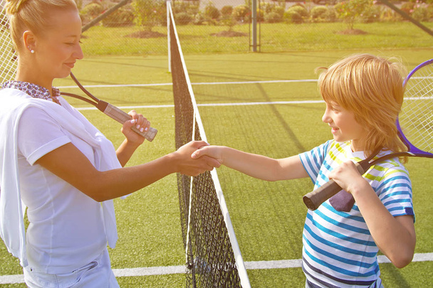 Tennispelaajat kättelevät ennen tennisottelua ja sen jälkeen. Kuvassa se näyttää kättelevän toisiaan läheisesti
. - Valokuva, kuva