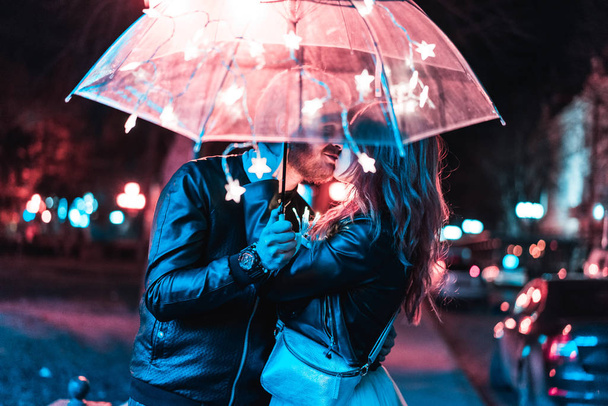 Хлопець і дівчина цілуються під парасолькою
 - Фото, зображення