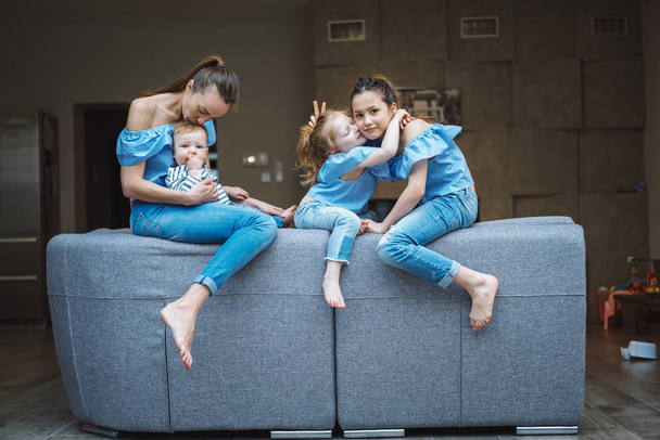 Mom, two daughters and a little son on the couch - Фото, изображение