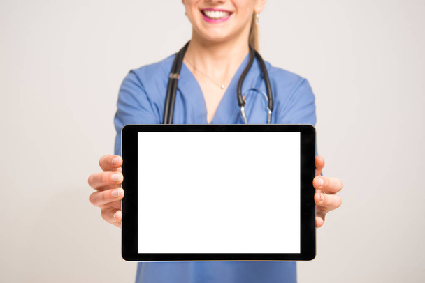 Nurse showing a tablet screen - Zdjęcie, obraz