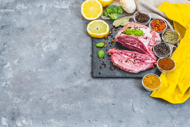 Fresh raw meat with spices over grey background - Foto, afbeelding