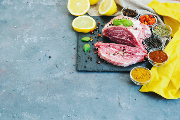 Fresh raw meat with spices over grey background - Foto, afbeelding