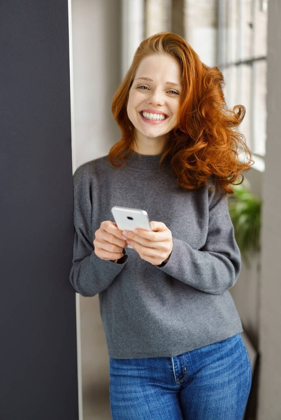 Ecstatic young woman holding a mobile phone - Fotografie, Obrázek