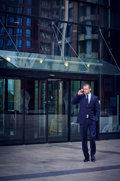 businessman talking on cellphone while walking from of office bu - Valokuva, kuva