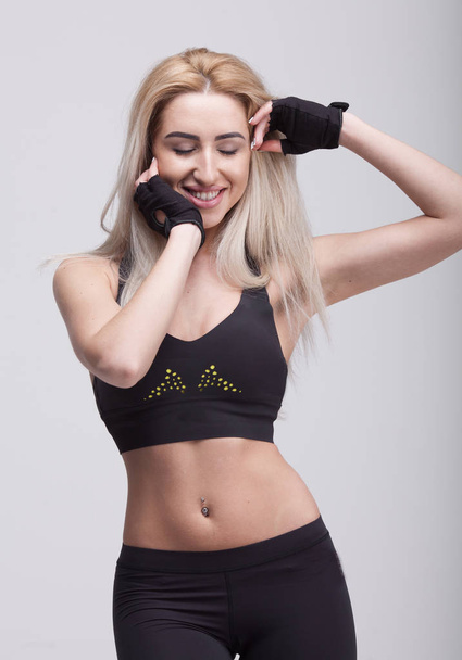 Young beautiful woman in fitness wear over grey background - Φωτογραφία, εικόνα