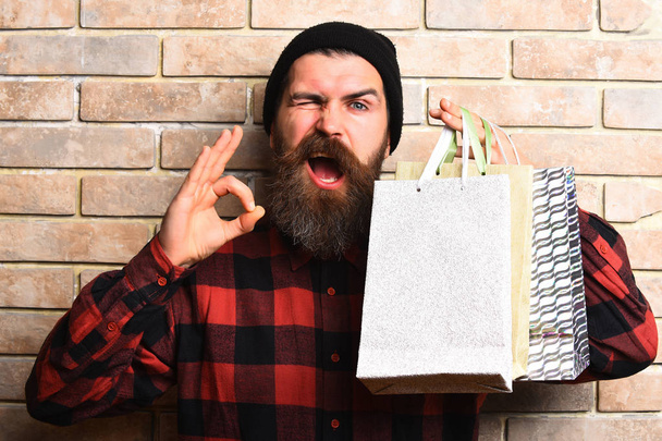 Bearded brutal caucasian hipster with moustache holding shopping packages - Foto, Imagem