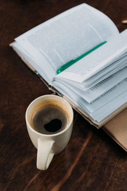 primer plano de la taza de café con libro y pluma en la mesa de madera
 - Foto, Imagen