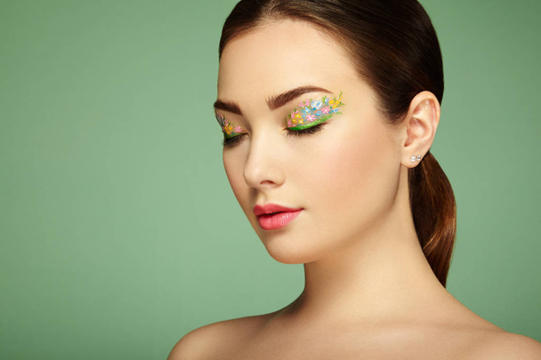 Young beautiful woman with flower makeup eyes - Foto, Bild