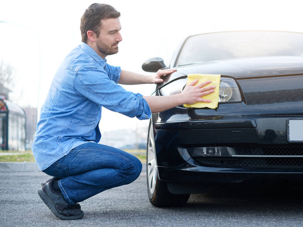 Man verzorgen en zijn auto schoonmaken - Foto, afbeelding