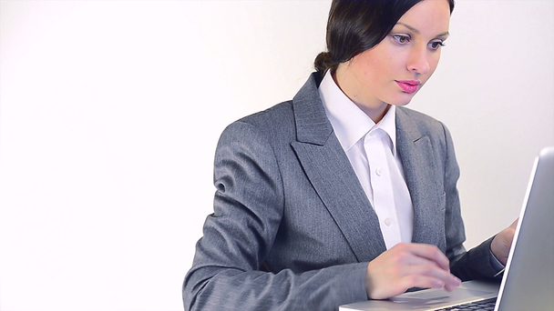 Houkutteleva hymyilevä nuori liiketoiminnan nainen käyttää kannettavaa tietokonetta
 - Materiaali, video