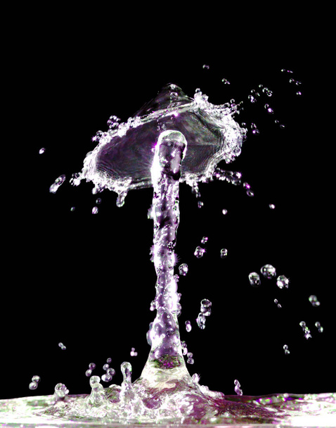 Salpicadura de líquido colorido sobre fondo negro
 - Foto, Imagen