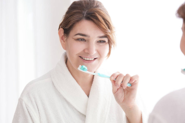 Senior woman cleaning teeth  - Фото, зображення