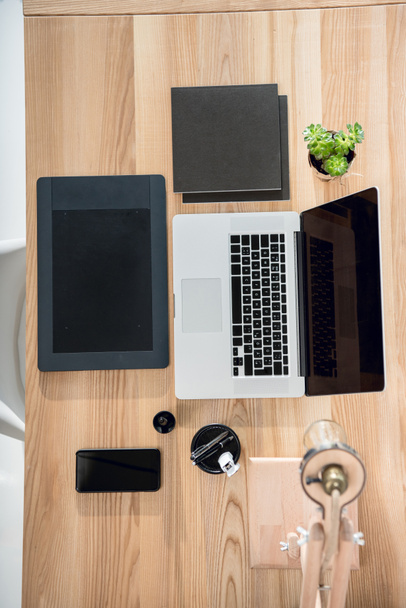 ноутбук с графическим планшетом и смартфоном на рабочем столе
 - Фото, изображение