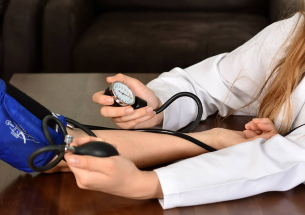 Cropped image of Female doctor checking blood pressure of patient at table          - Foto, Imagen