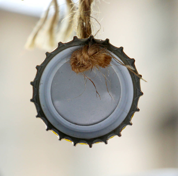Крышка бутылки повешена на веревке
 - Фото, изображение