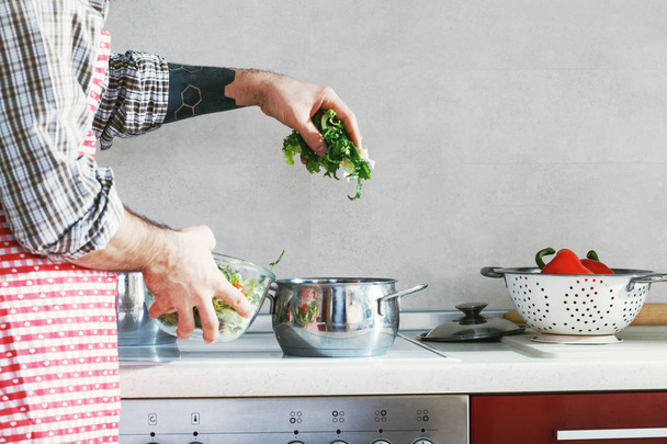 bearded man cooking healthy vegetable salad  - Zdjęcie, obraz
