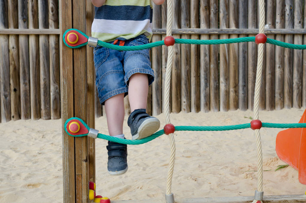 Petit garçon grimpant sur un cadre d'escalade
 - Photo, image
