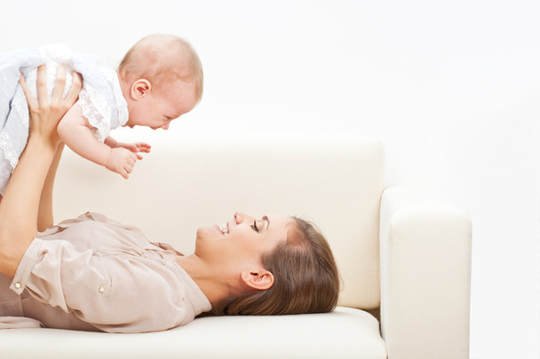 Mother and baby laying on sofa - Foto, Bild