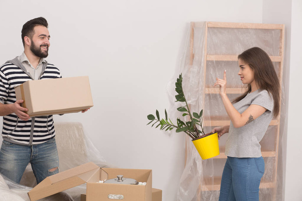 Young happy couple unpacking boxes after moving in new home. - Φωτογραφία, εικόνα