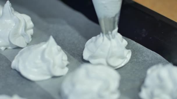 Meringue is laid out on a baking sheet, homemade pastries, cake, cookies made at home meringues - Filmati, video