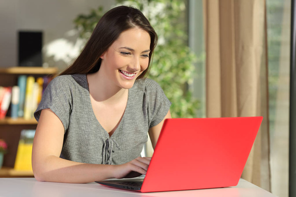 Escritor escrevendo em um laptop vermelho em casa
 - Foto, Imagem