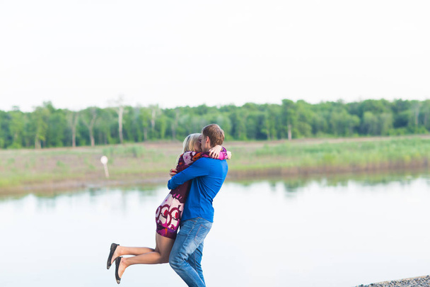 beautiful young couple in love embracing near the lake. - 写真・画像