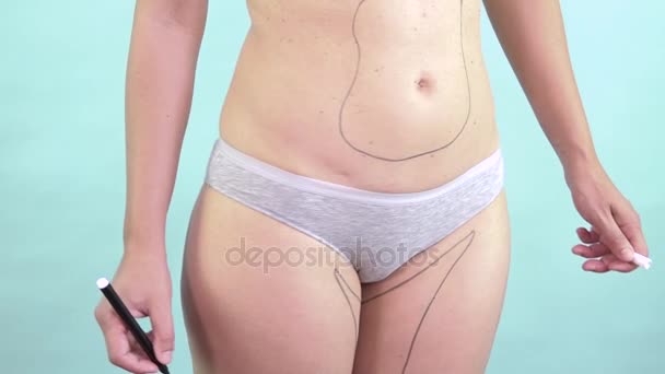 Mujer dibujando en su cuerpo líneas de cirugía plástica para adelgazar y reducir la grasa
 - Imágenes, Vídeo