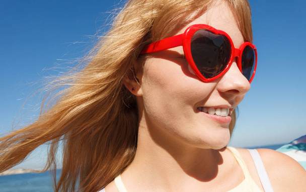Girl in red sunglasses relaxing on sea coast. - Zdjęcie, obraz
