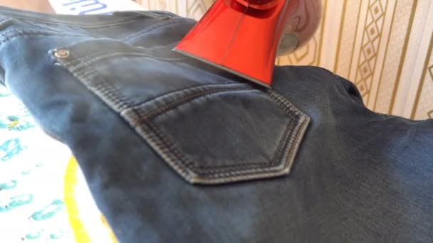 Mann dampft Jeansstoff auf Bügeltisch - Filmmaterial, Video
