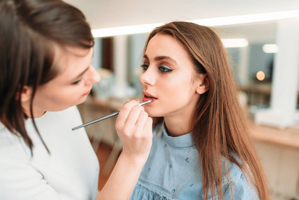 make up artist applying gloss on lips - Foto, imagen