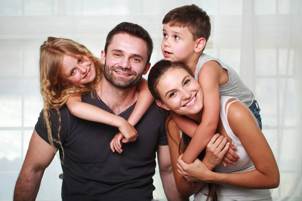 glückliche Familieneltern und zwei Kinder zu Hause - Foto, Bild