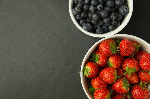 Strawberries and blueberries in bowls - Фото, зображення