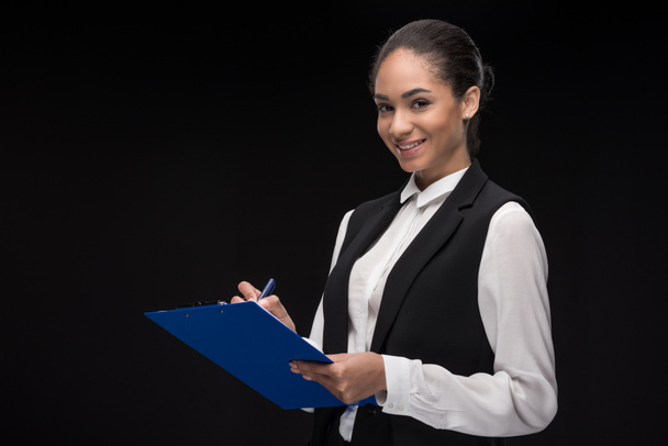 young businesswoman standing with clipboard - Foto, afbeelding