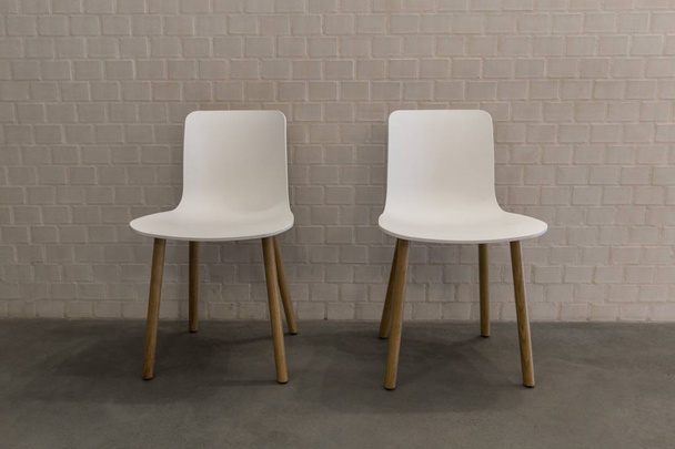 белые стулья по кирпичной стене
 - Фото, изображение